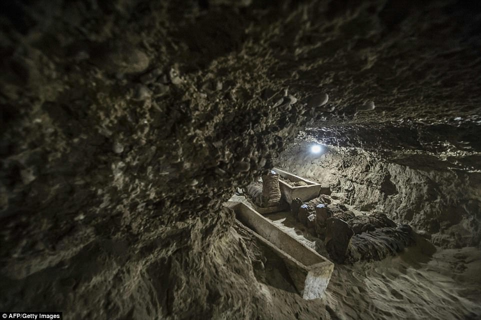 Mummies are pictured next to open coffins in one of the tomb's passageways